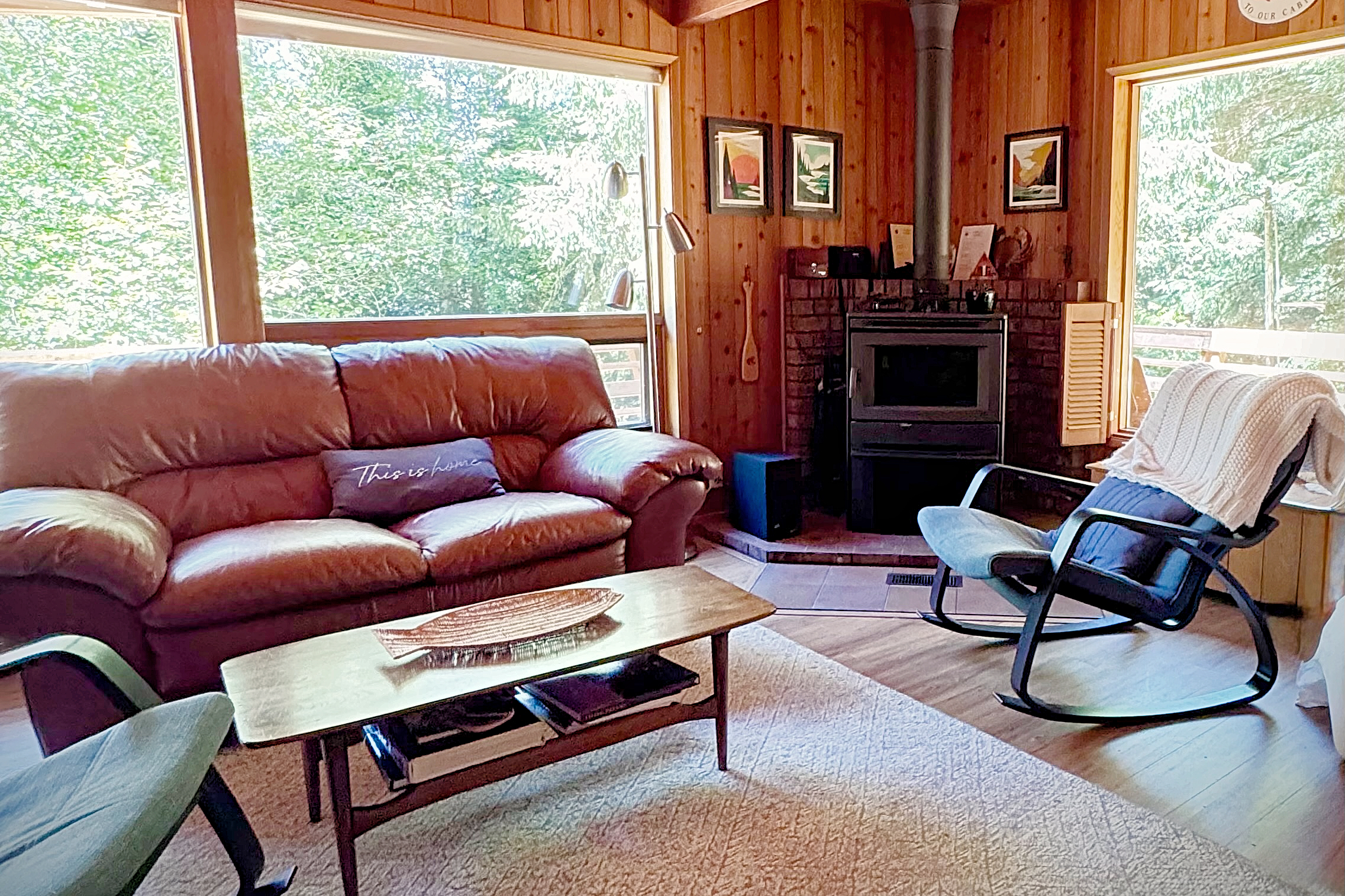 The living room, with a wood stove and forest views.